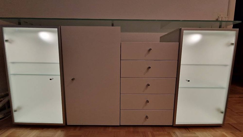 Sideboard elegante in bianco con piano in vetro e illuminazione