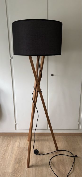 Lampada da terra con paralume nero e gambe in legno